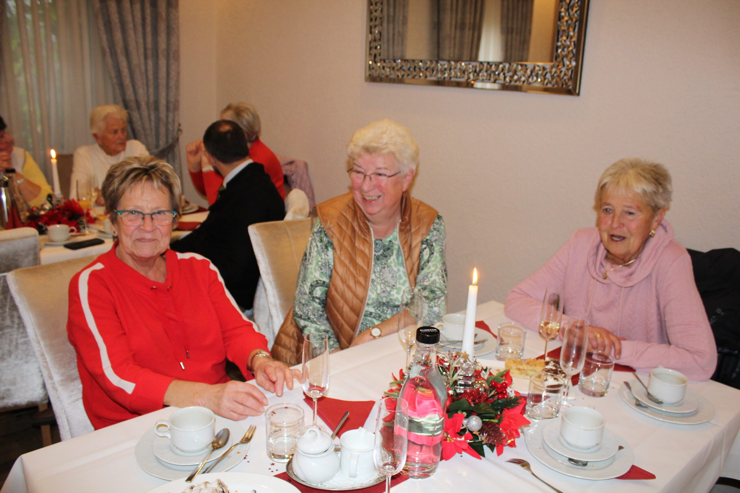 Drei Frauen sitzen an einem Tisch und unterhalten sich.