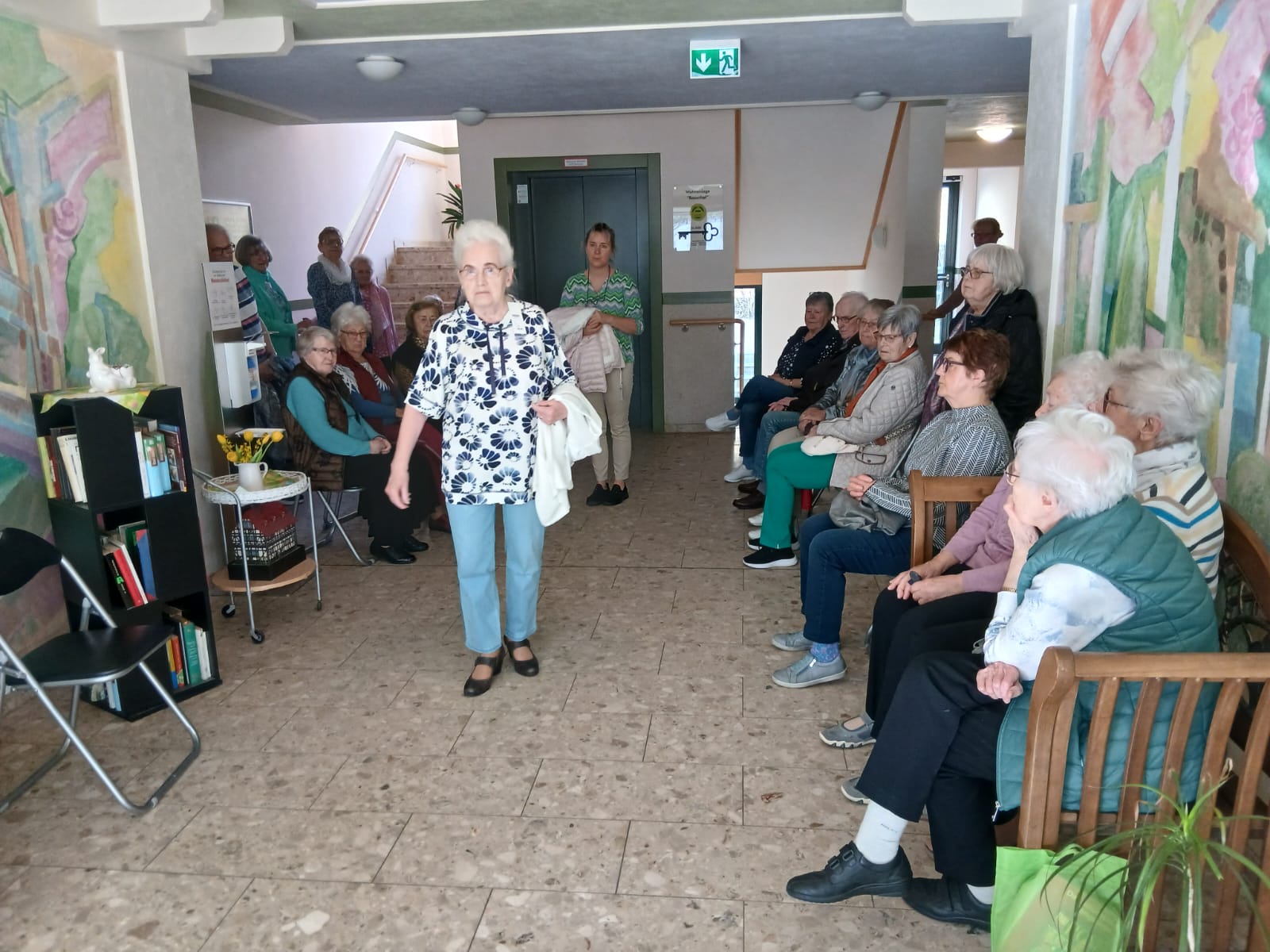 Das Foto zeigt Ursula Wiesche auf den Laufsteg. Soe präsentiert eine weiße Bluse mit schwarzen Ornamenten.